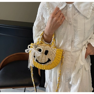Detail of straw bag featuring woven smile face, pearl accents and white lace bow