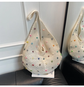 Close-up of beige crochet tote bag featuring colorful pearl beads and net mesh design
