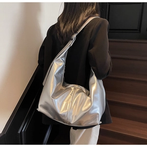 Détail d'un grand sac hobo argenté métallisé avec texture plissée et large bandoulière