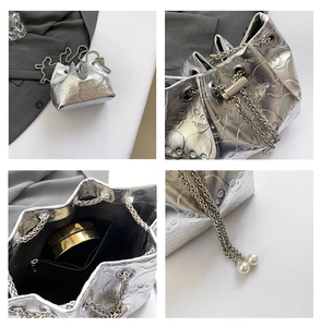 Detail view of silver skull bucket bag with chain strap and elegant pearl accents