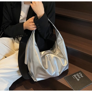 Détail du sac hobo argenté sur mannequin montrant la grande capacité et la texture du cuir