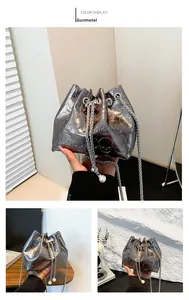 Detailed gunmetal bucket bag with embossed skull patterns and white pearl chain strap