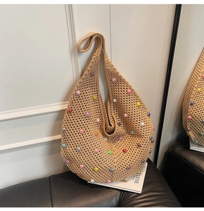 Detail of bohemian beige crochet tote bag with colorful pearls and hollow knit texture