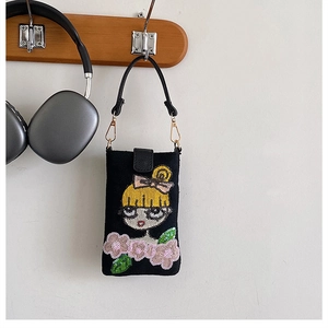Détail du mini sac bandoulière avec broderie de fille en paillettes sur tissu noir