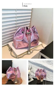 Detail of metallic pink bucket bag with skull embossing, silver chain and pearl charms