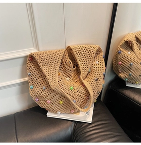 Detail of hand-woven straw shoulder bag with colorful beads for beach vacations