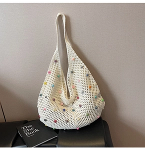 Detail of crochet tote bag with colorful pearl beads on cream woven fabric
