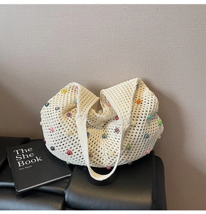 Detail of crochet tote bag with colorful pearls and openwork mesh knit texture