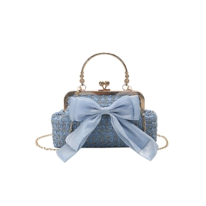 Light blue tweed handbag with a chiffon bow, golden chain strap, and ornate metal handle