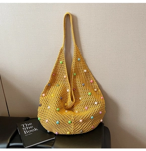 Detailed knit texture of yellow hollow-out shoulder bag with colorful pearl embellishments