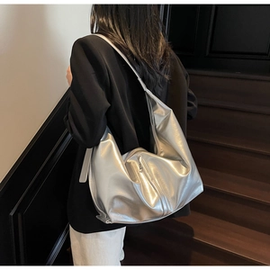 Détail du sac hobo métallisé argenté avec texture brillante et poche zippée pratique
