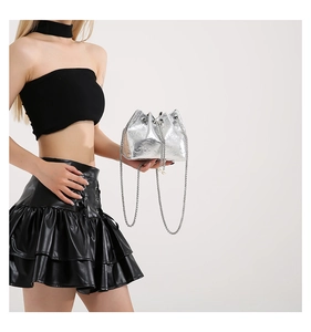 Detail of silver bucket bag with skull embossing, chain strap and pearl drawstring charms