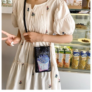 Gros plan d'un mini sac à bandoulière noir à paillettes avec motif de frites colorées