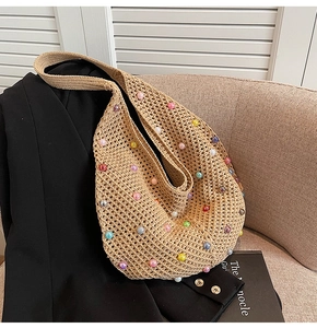 Close-up of beige crochet bag featuring colorful pearls and intricate knit texture