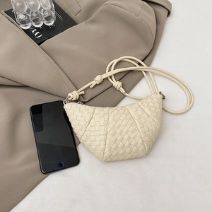 Beige hand-woven croissant crossbody bag shown with smartphone for size reference