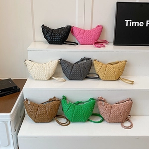 Handwoven croissant-style crossbody bags in eight vibrant colors on tiered display