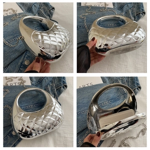 Detail view of silver acrylic evening bag with diamond quilting and metal handle