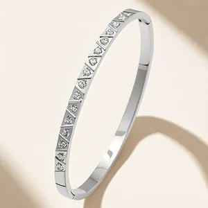 Macro detail of silver stainless steel bangle with triangular-cut crystals in a row