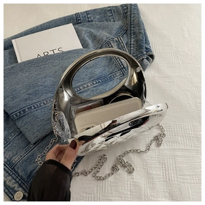 Internal view of silver acrylic round clutch bag showing capacity for phone and makeup