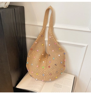 Detailed close-up of beige knit shoulder bag featuring colorful pearl bead decorations