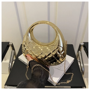 Detail of gold crescent evening bag with quilted pattern and round cutout handle