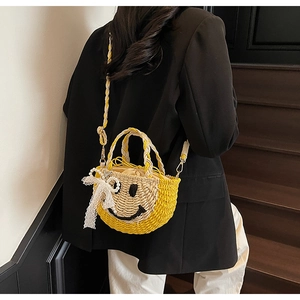 Detail of yellow straw bucket bag with smiley face and lace bow on a black blazer