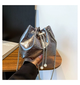 Macro shot of silver bucket bag featuring skull embossing and pearl drawstring detail