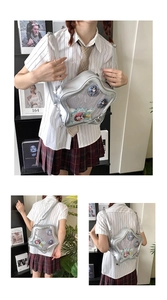 Detailed view of silver star-shaped Ita bag with transparent window showing anime badges