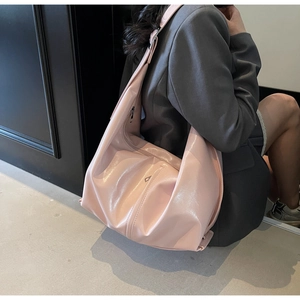 Détail du grand sac croissant rose poudré avec plaque métallique triangulaire chic
