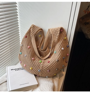 Detail of hollow-knit beige hobo bag with multi-colored pearls and woven texture