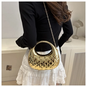Detail of gold semicircular crossbody bag featuring quilted pattern and chain strap on model