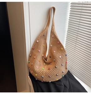 Detailed close-up of woven mesh shoulder bag with colorful bead accents and hollow texture