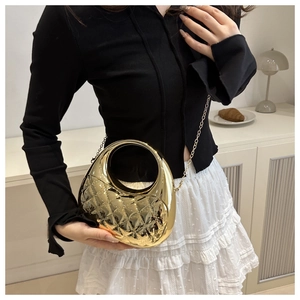 Detail of gold mirror acrylic handbag featuring quilted texture and chain strap