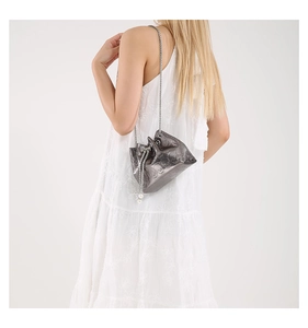 Detail of metallic grey bucket bag with skull embossing, chain strap and pearl charm