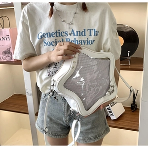 Primer plano de un bolso blanco en forma de estrella con ventana transparente y tachuelas
