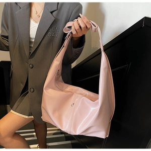 Détail du sac hobo rose clair brillant montrant sa grande capacité et son cuir PU verni