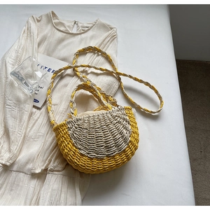 Macro detail of dual-tone straw woven bag texture with crossbody straps and top handles