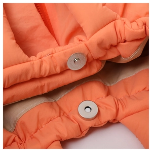 Macro view of orange quilted fabric and metal magnetic closure on large capacity tote bag