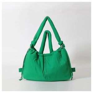 Detail view of the green quilted nylon shoulder bag with drawstring side and wide strap