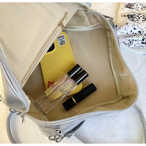 Internal view of silver star crossbody bag with zipper pocket showing daily essentials