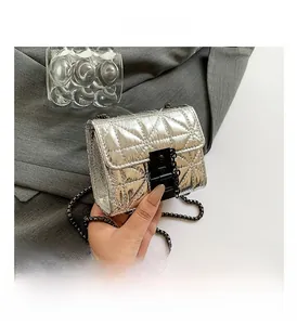 Detail view of silver quilted crossbody bag with metallic chain and industrial buckle
