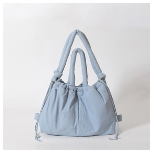 Close-up of quilted nylon shoulder bag with drawstring closure and dual handles