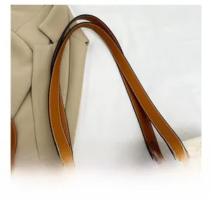 Detail of soft cream woven fabric with brown faux leather straps and white contrast stitching