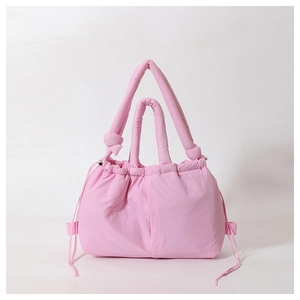 Detailed view of the soft quilted puffer texture on the light pink nylon tote bag