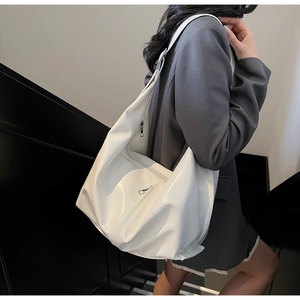 Vue détaillée du sac cabas blanc en cuir verni avec une poche latérale zippée