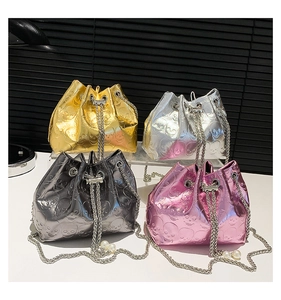 Detail of four metallic drawstring bucket bags with 3D skull embossing and pearl chains