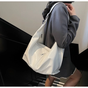 Gros plan d'un grand sac bandoulière blanc en similicuir avec zip sur un mannequin