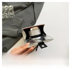 Detail view of mini silver quilted chain bag interior showing storage for cosmetics