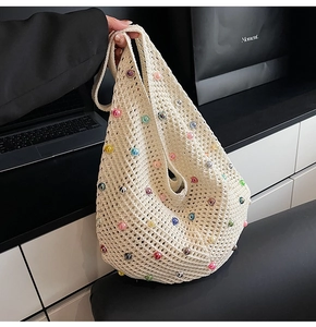 Close-up of cream handmade crochet tote bag featuring colorful faux pearls and mesh detail