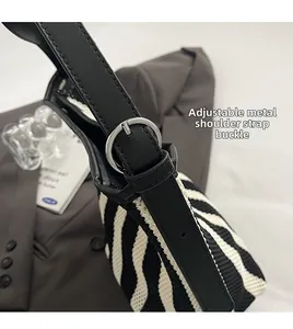 Detailopname van de verstelbare zwarte leren riem met zilveren gesp op zebra tas